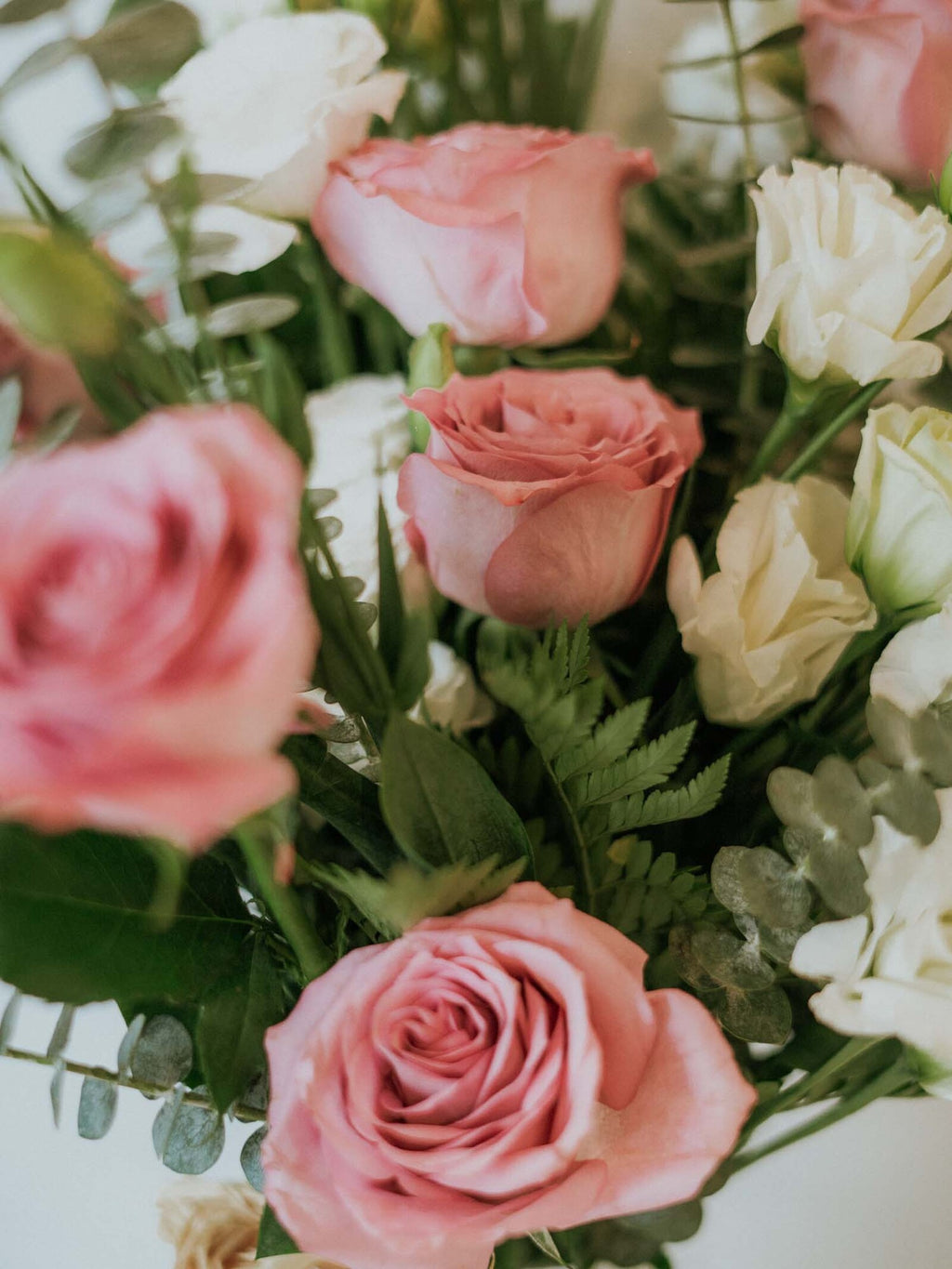 Hand tied bunch of 14 stems of purple roses and white lisisanthes and 2 stems of white Delphinium